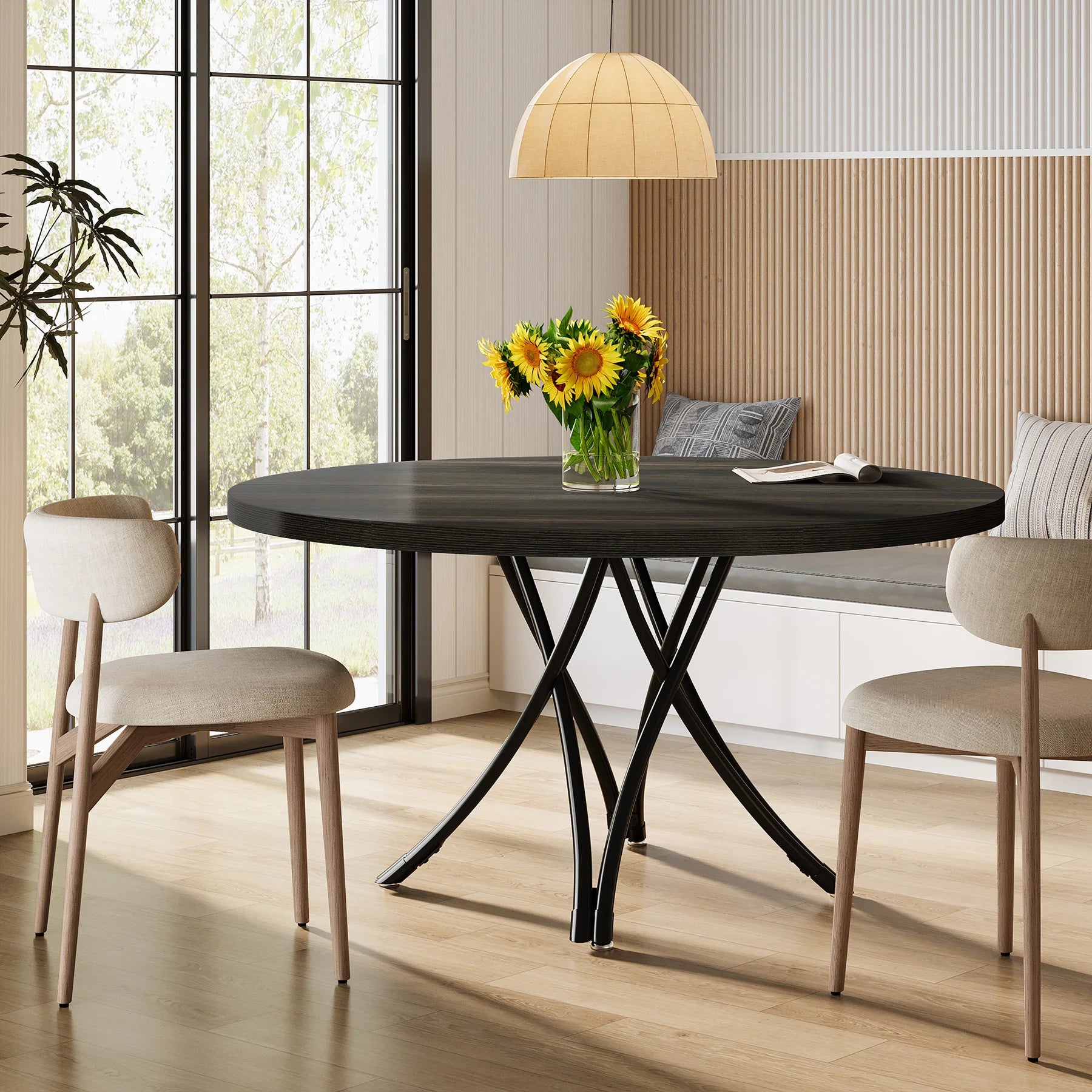 Dining room with a black round table, chairs, and a vase of sunflowers.