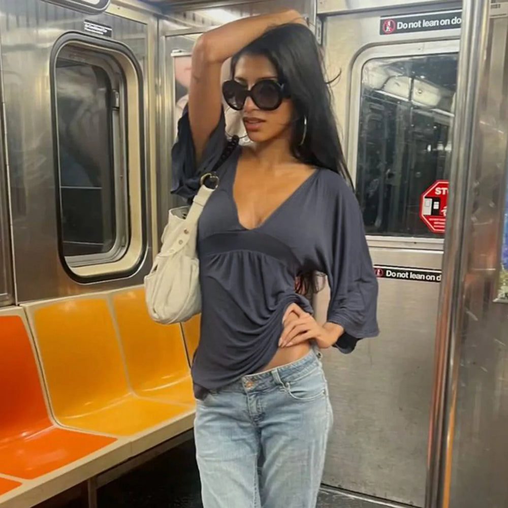 Woman posing on a subway train with orange seats and metal walls.