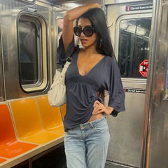 Woman posing on a subway train with orange seats and metal walls.