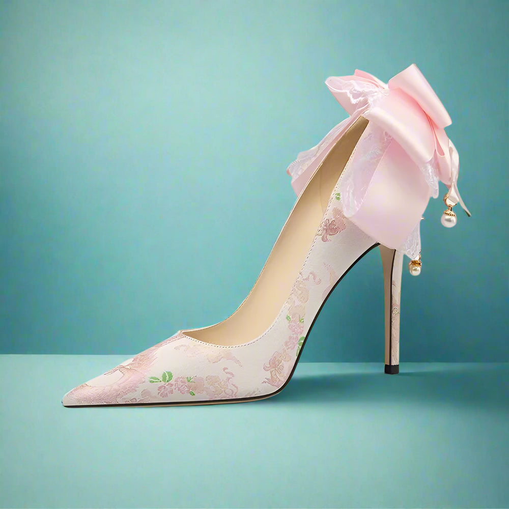 High-heeled shoe with floral design and pink bow on a white background
