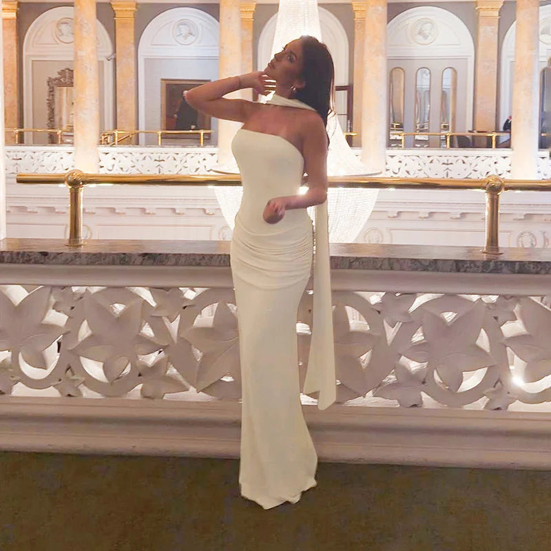 Woman in a white strapless gown standing in an elegant interior setting.