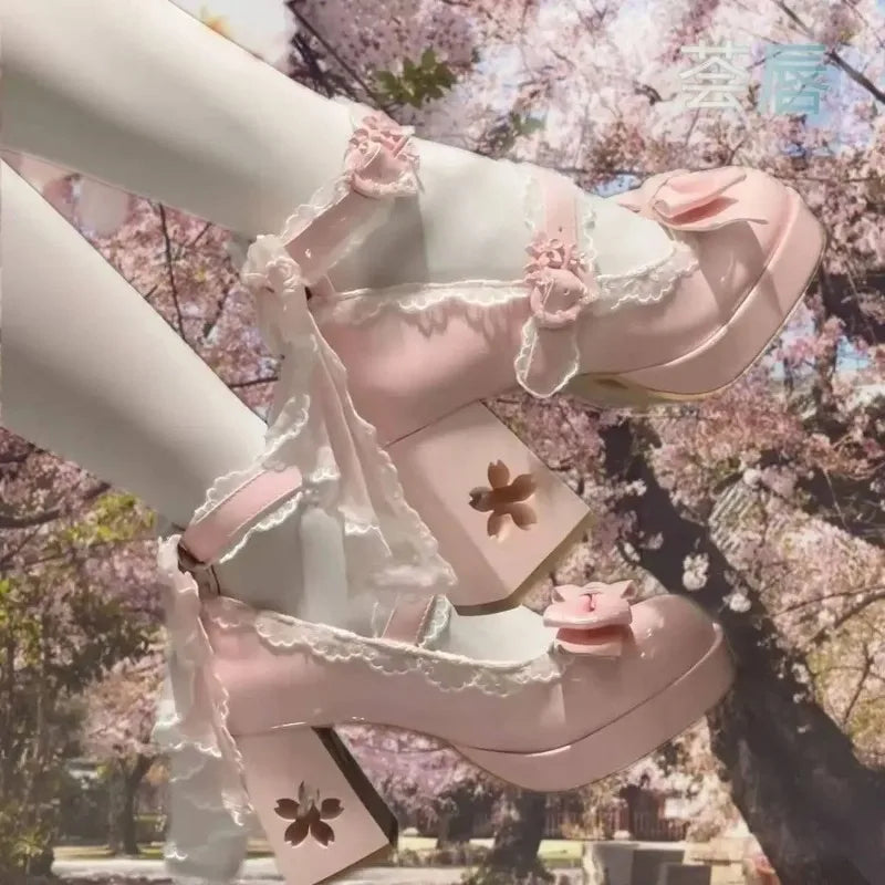 Pastel pink sandals with floral details worn by a person against a cherry blossom background
