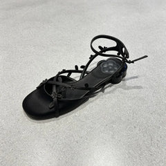 Close-up of black silk floral kitten heel sandal detail