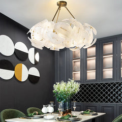 A modern glass petal chandelier with LED lights casting a warm glow over a dining room table. 4