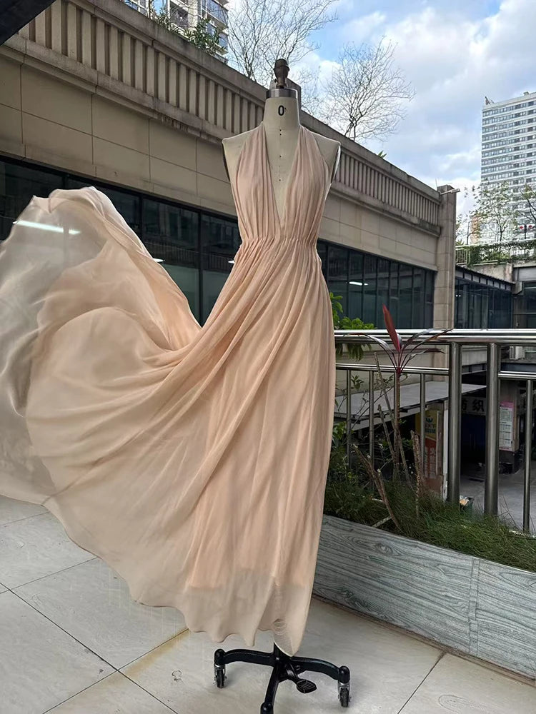 Beige evening gown on a mannequin outdoors with buildings in the background