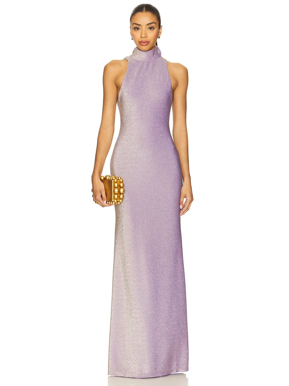 Woman wearing a purple evening gown holding a gold clutch on a white background