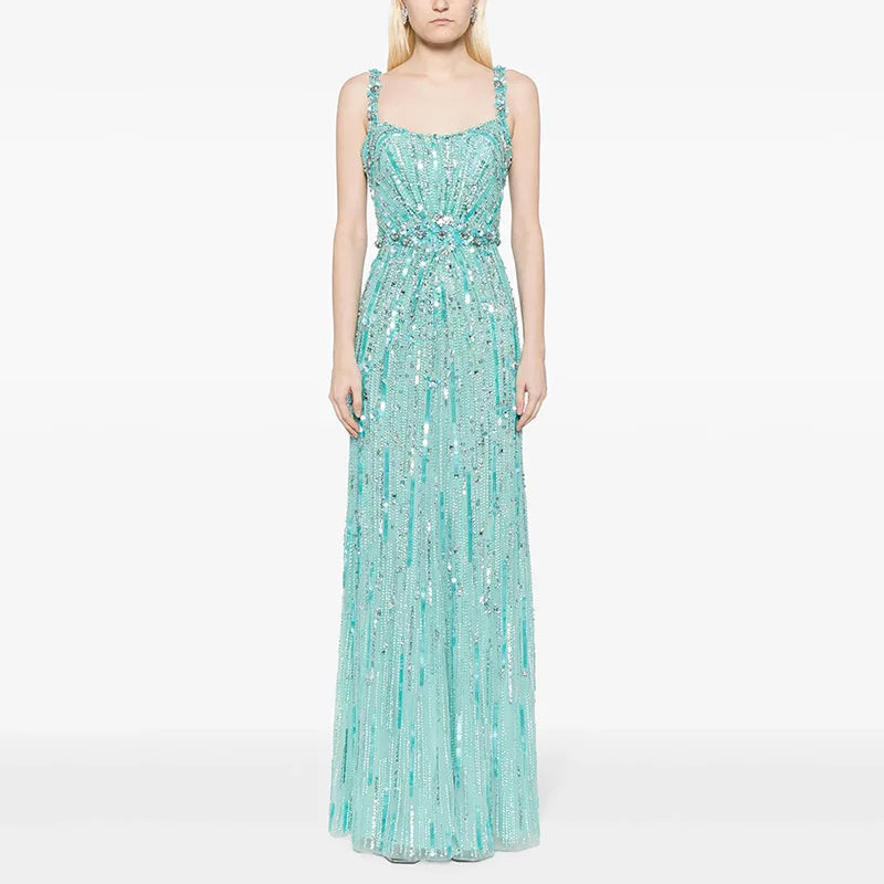 Woman wearing a turquoise sequin dress on a white background