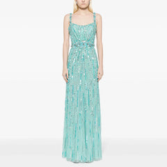 Woman wearing a turquoise sequin dress on a white background