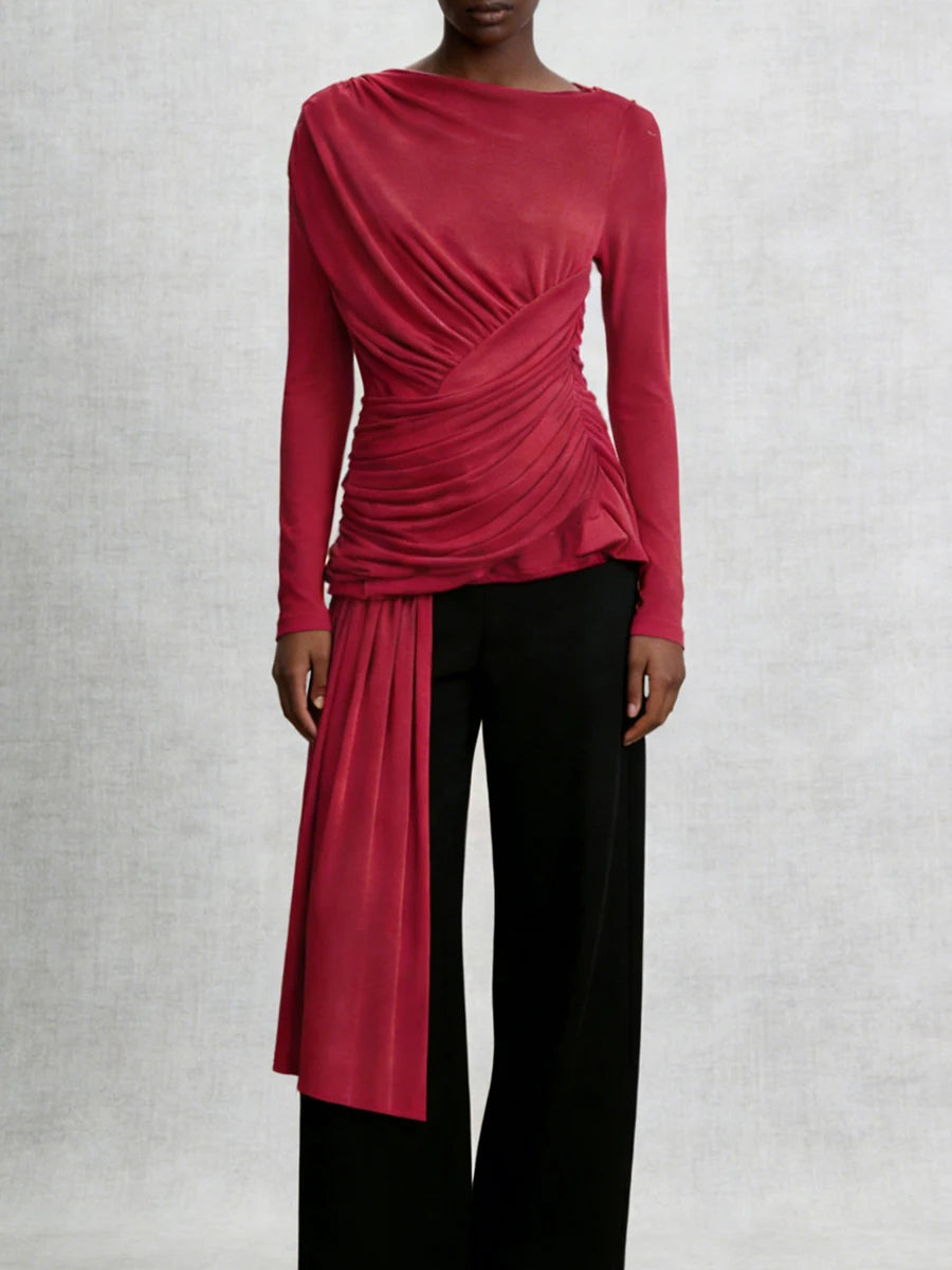 Red long-sleeve top with a draped design worn by a person on a light gray background