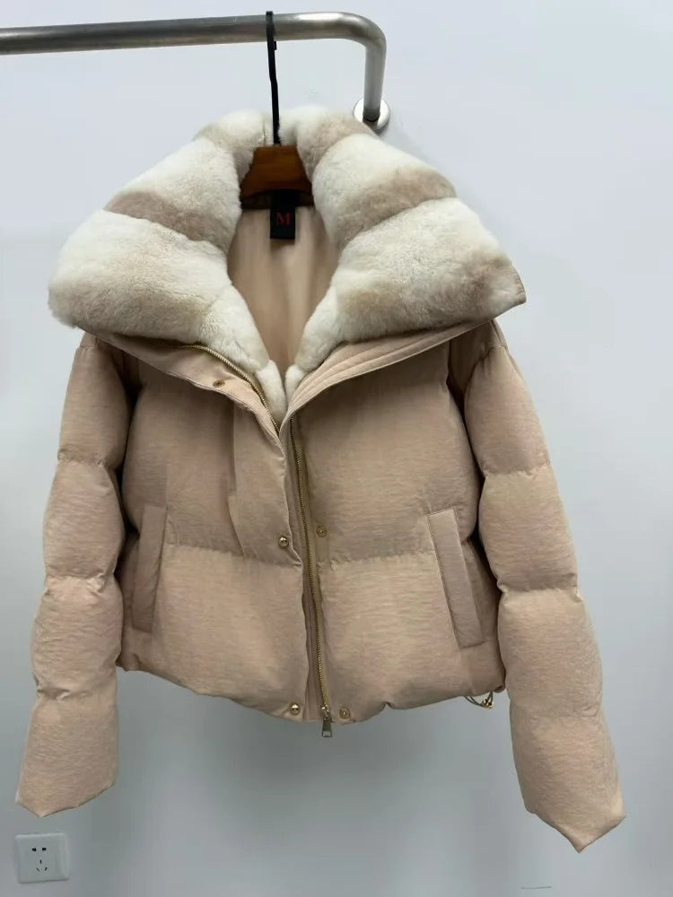 Beige puffer jacket with fur-lined hood on a hanger against a plain background