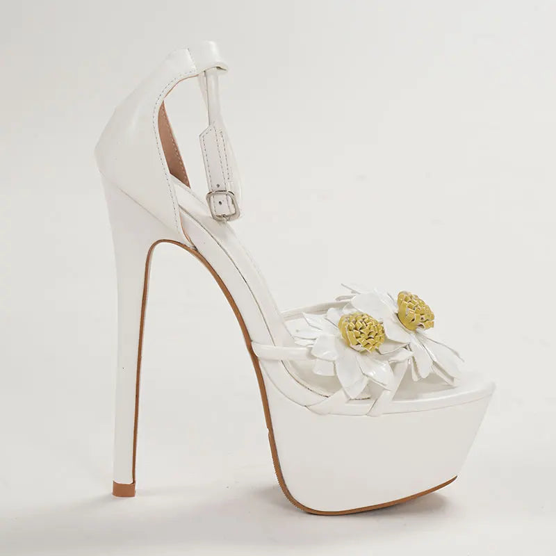 White high-heeled shoe with floral decorations on a light gray background
