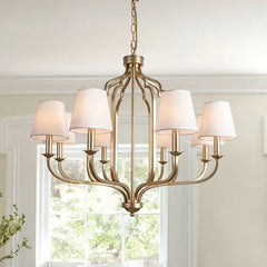 A retro-style chandelier with an iron frame, hanging in a spacious living room with high ceilings.