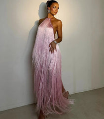 Woman wearing a pink fringe evening gown against a plain background