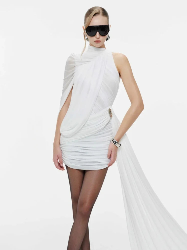 Woman wearing a white dress with flowing fabric on a plain background