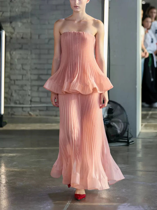 Model wearing strapless top and pleated midi skirt set on runway