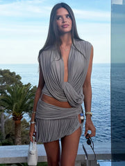 Gray draped V-neck sleeveless top and ruched mini skirt set by the sea