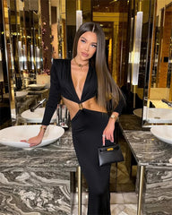 Woman in a black outfit standing in a luxurious interior setting.