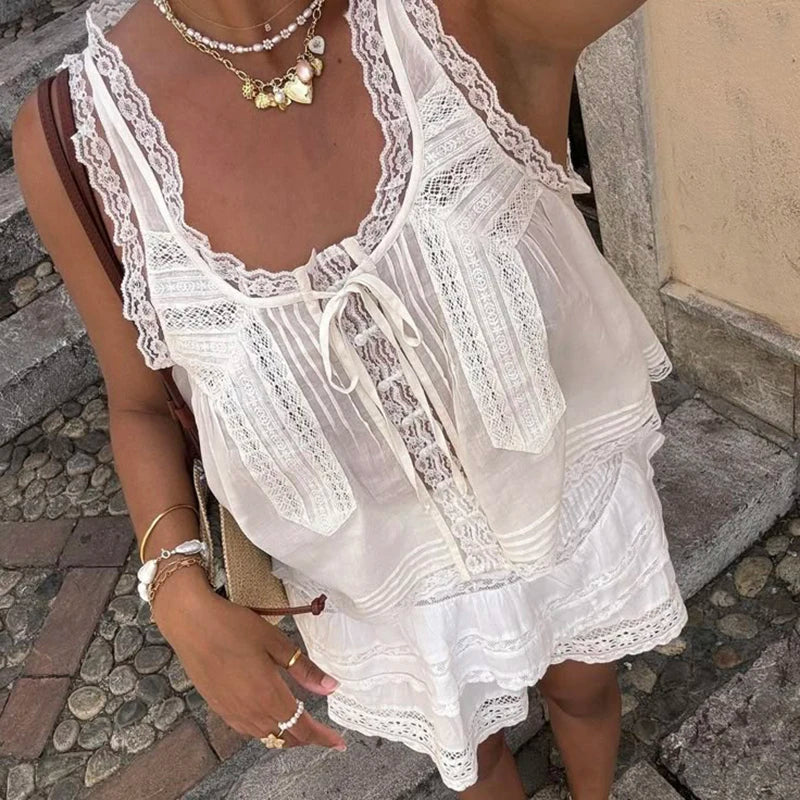 White lace dress worn by a person on a stone pavement.