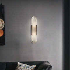 A sleek marble wall sconce with a warm LED light, illuminating a modern bedroom with a minimalist aesthetic. c