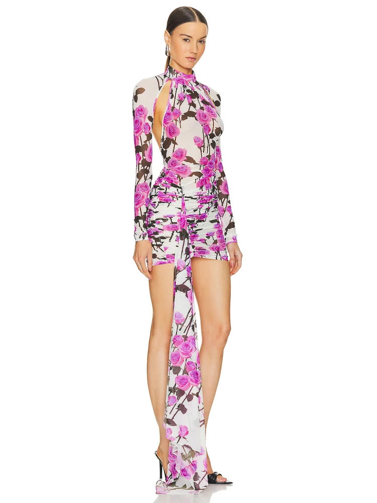 Woman wearing a floral dress with a high slit on a white background.