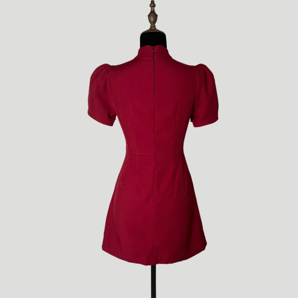 Red dress on a mannequin against a plain background