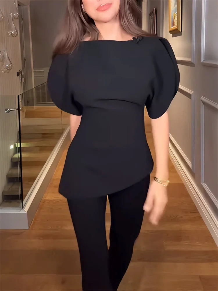 Person wearing a black outfit with puffed sleeves in an indoor setting