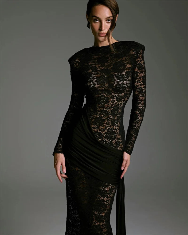 Model wearing a black lace dress against a gray background
