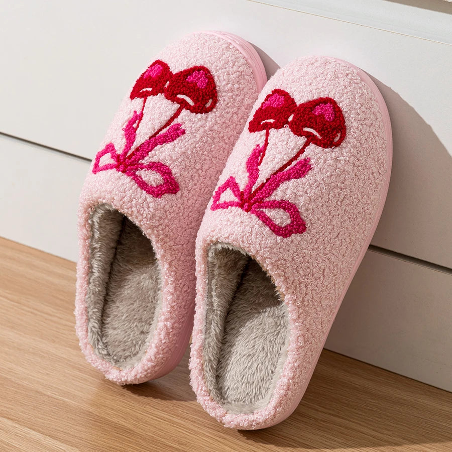 Pair of pink plush slippers with cherry bow detail