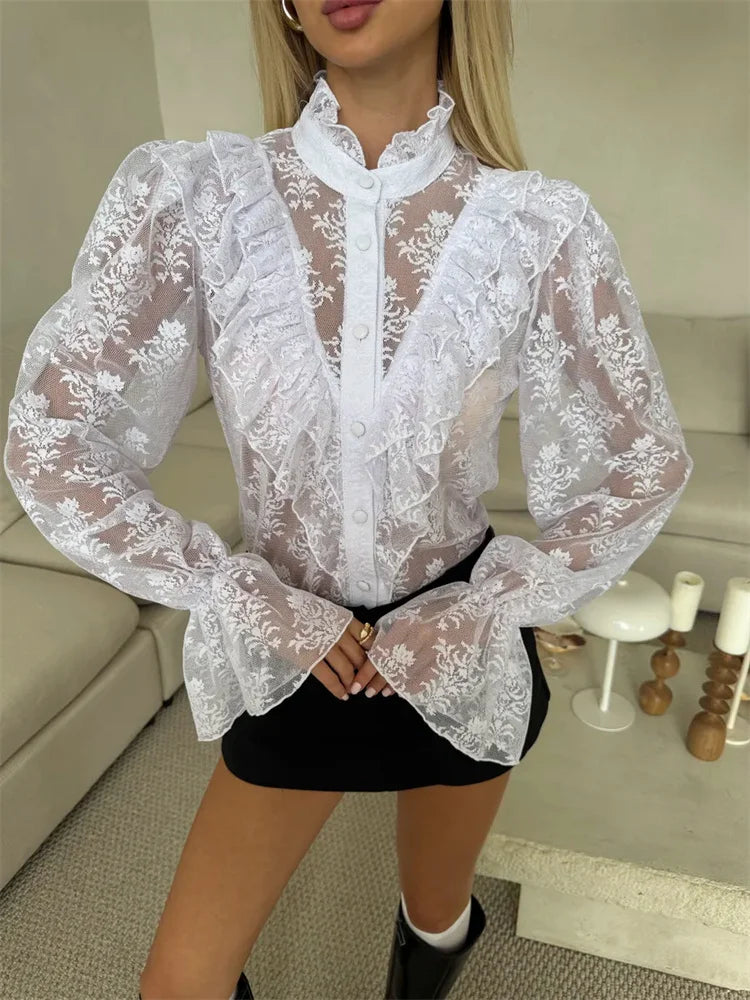 Person wearing a white lace blouse in a living room setting