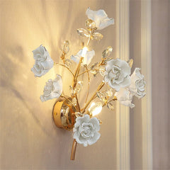 Decorative wall light fixture with white floral designs on a beige wall.