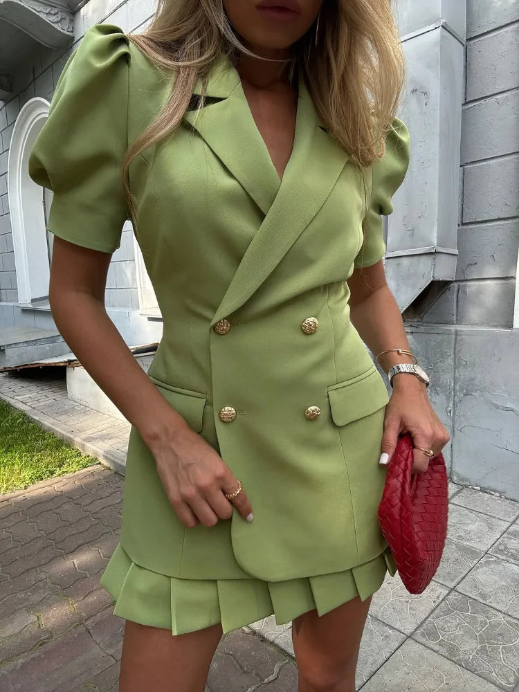 Woman wearing a green dress with gold buttons, standing outdoors.