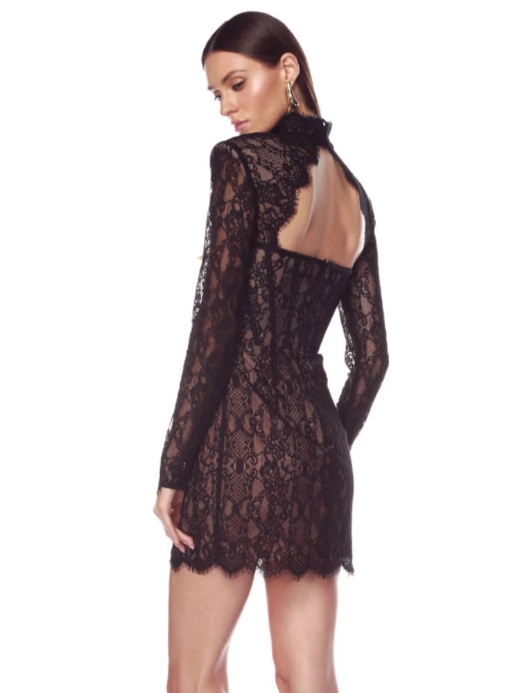 Black lace dress with long sleeves and open back on a white background