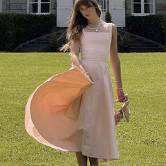 Woman wearing a pink A-line sleeveless cotton midi dress with square neckline, summer fashion