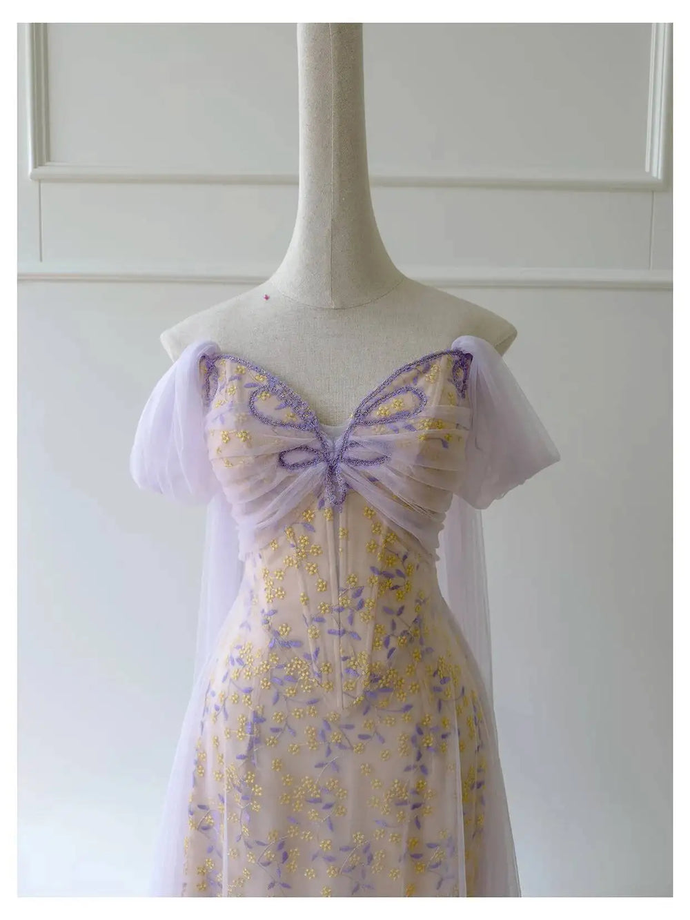 Close-up of the embroidered butterfly bodice on the tulle overlay dress