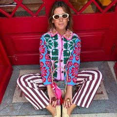 Model wearing a colorful floral print quilted jacket with blue and red floral accents.