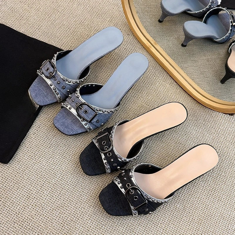 Black denim kitten heels with studded metal buckle detail.