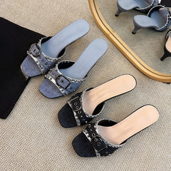 Black denim kitten heels with studded metal buckle detail.