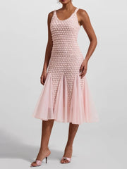 Woman wearing a pink textured dress on a white background