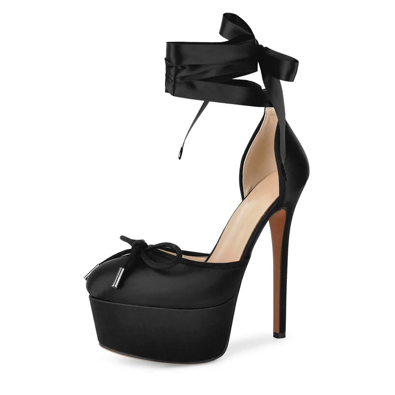 Black high-heeled platform shoe with bow detail on a white background