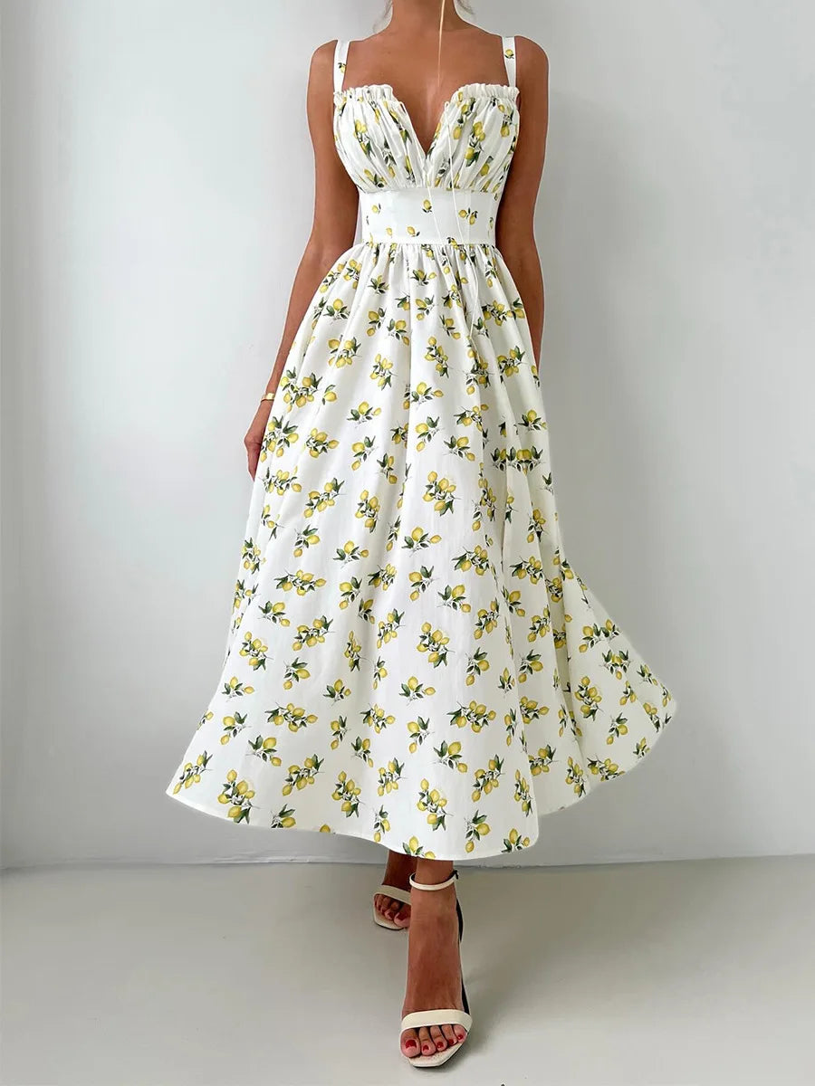 White dress with yellow floral pattern worn by a person on a plain background