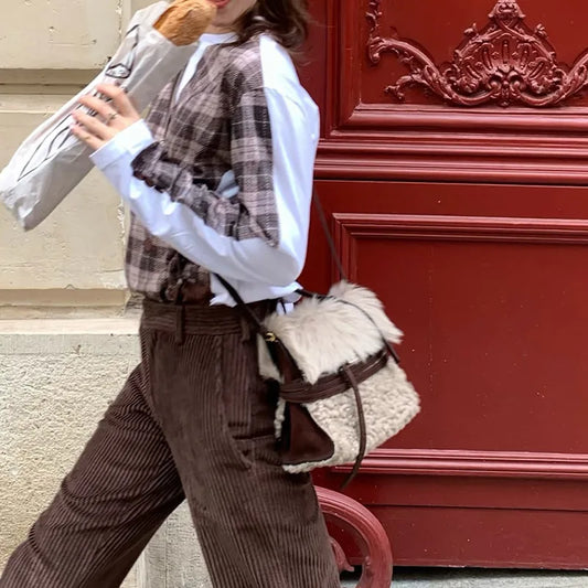 Small plush fur belted messenger bag worn crossbody.