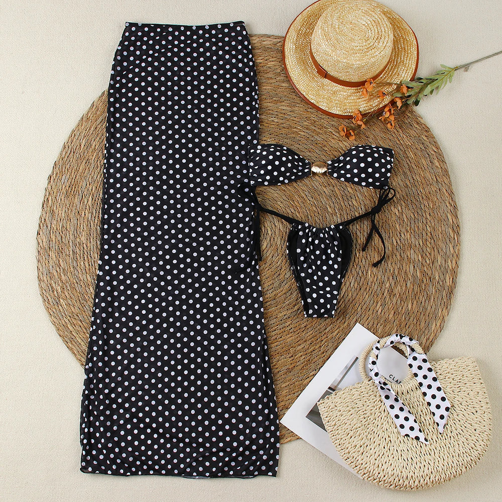 Flat lay of polka dot bikini, maxi skirt, straw hat, and beach bag