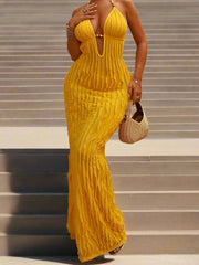 Woman wearing a yellow ribbed dress standing on stone steps.