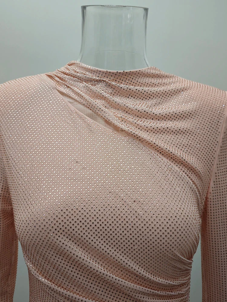 A mannequin wearing a apricot  mesh top against a plain background