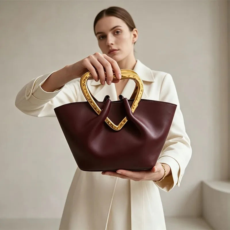 Woman holding burgundy heart handle bag