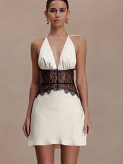 Back view of white halter neck mini dress with lace waist