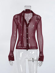 Sheer burgundy blouse on a mannequin against a white background