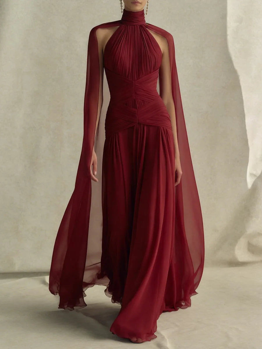 Woman wearing a red halter neck cape sleeve maxi dress