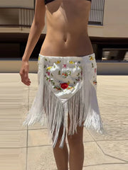Close-up of white floral embroidered mini skirt with fringe