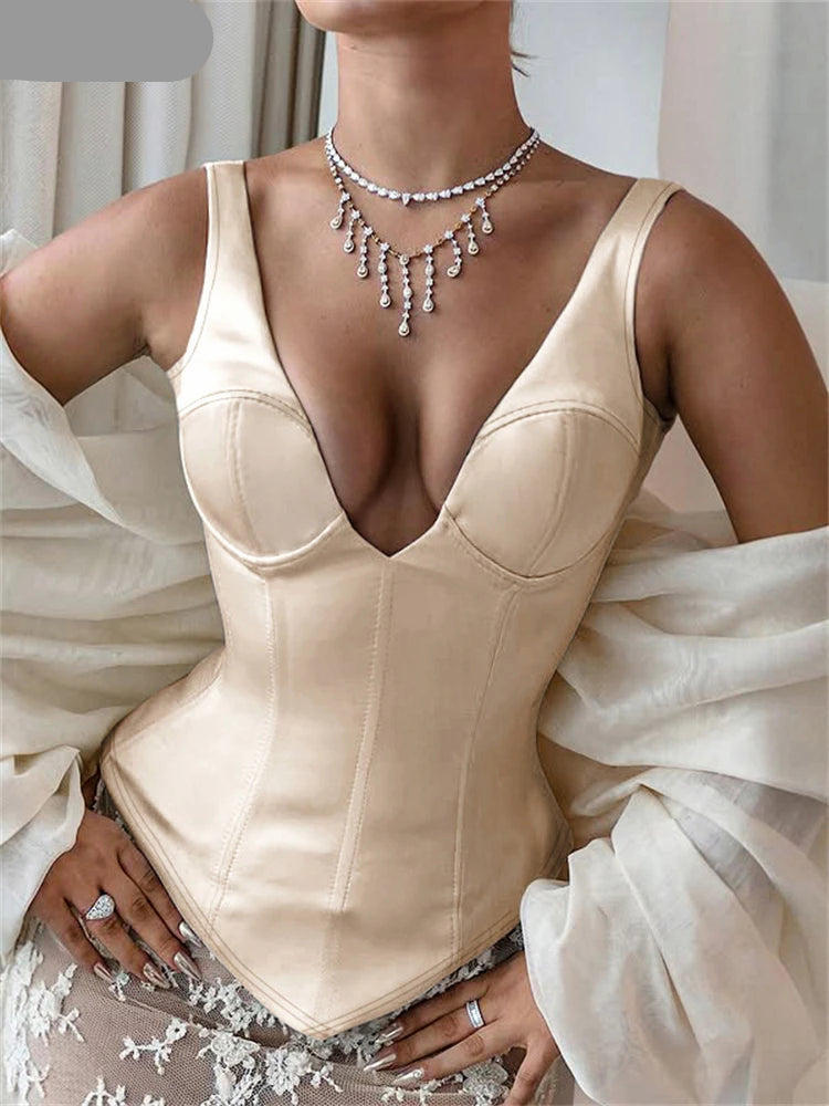 Woman wearing a beige corset with a white dress in the background
